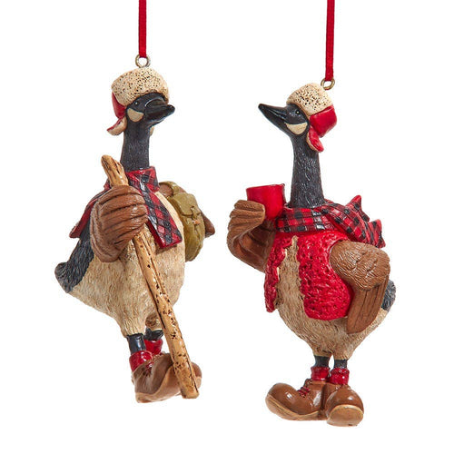Two decorative goose ornaments with winter attire on a white background