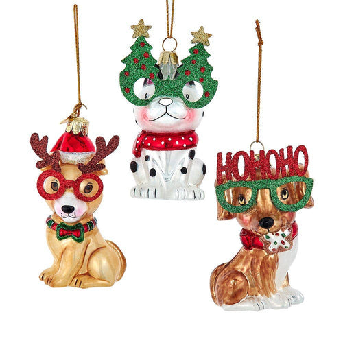 Three festive dog ornaments with Christmas-themed accessories on a white background