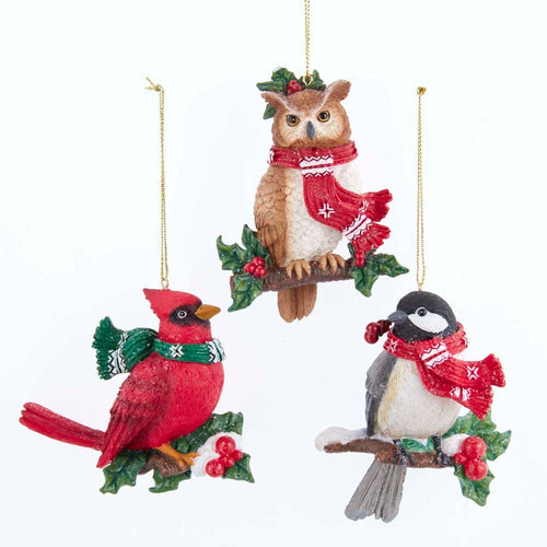 Three festive bird ornaments with scarves on a white background